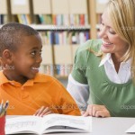 depositphotos_4759775-Kindergarten-teacher-helping-student-with-reading-skills