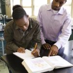 african_teacher_helping_student_in_chemistry_lab_bld065730